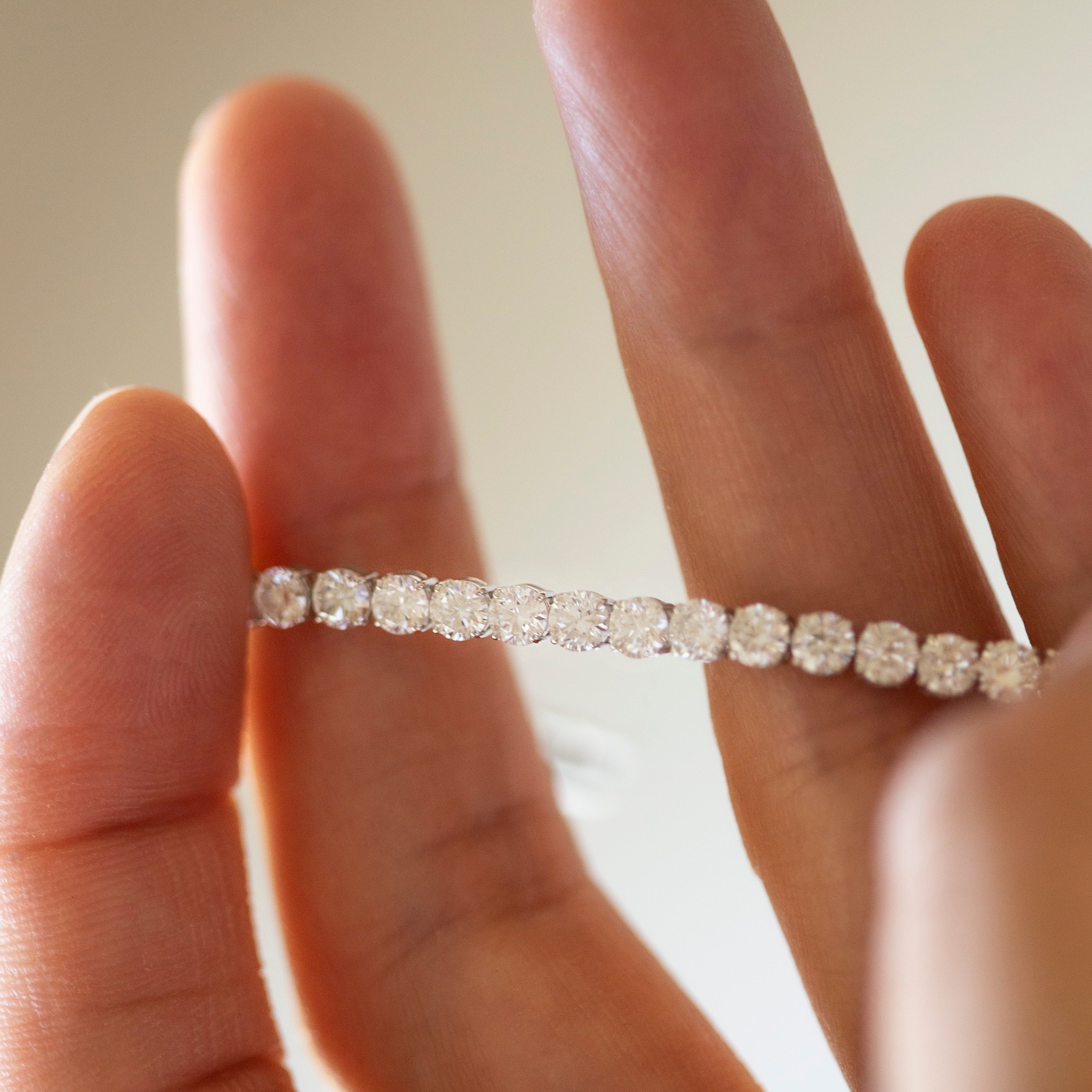 Diamond bracelet on a person's wrist with a neutral background