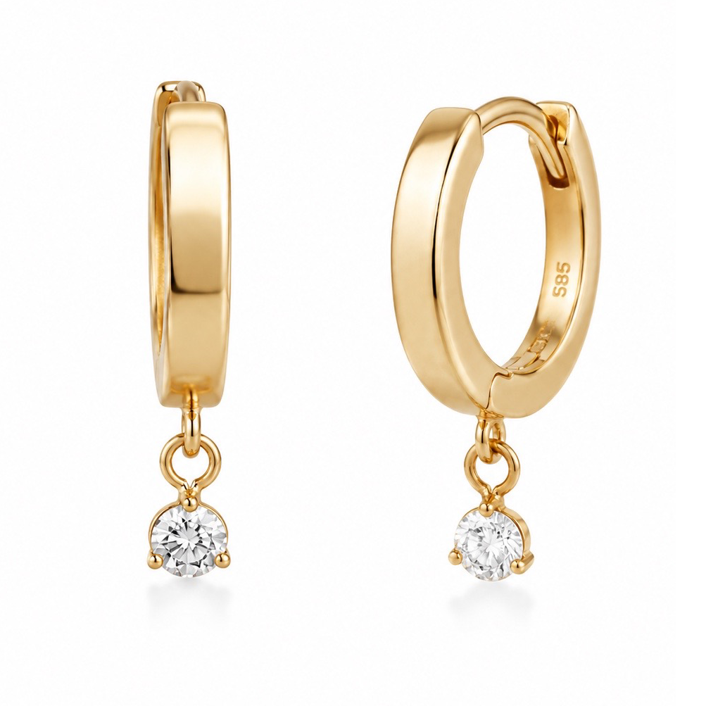 A pair of gold huggie hoop earrings with a small clear round-cut gemstone dangling from each hoop, shown on a clean white background.