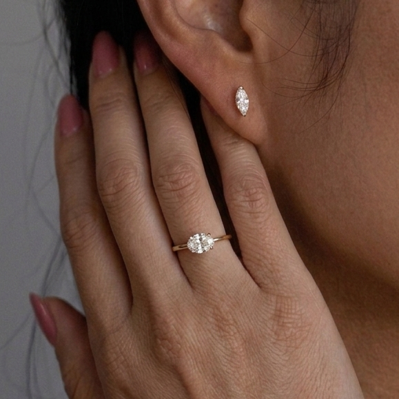 Close-up of a hand with a ring and an earring, focusing on jewelry details.