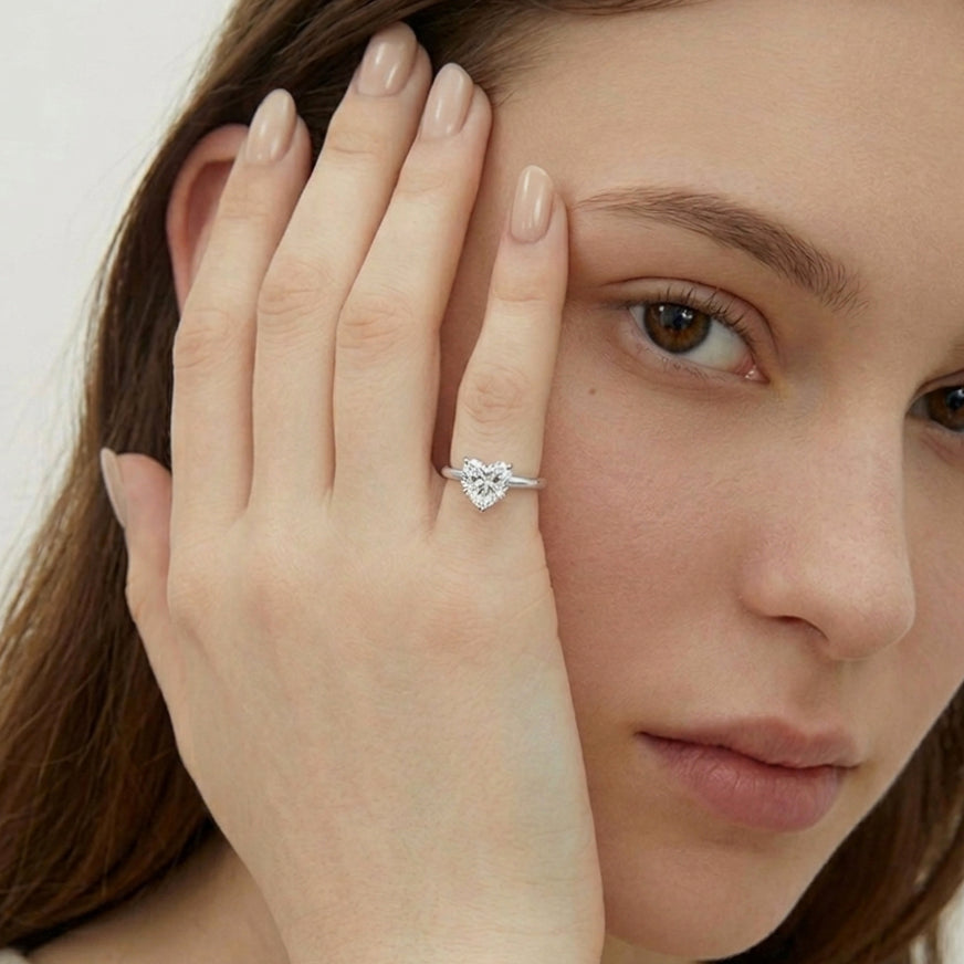 Woman wearing a diamond ring on her finger with a neutral background
