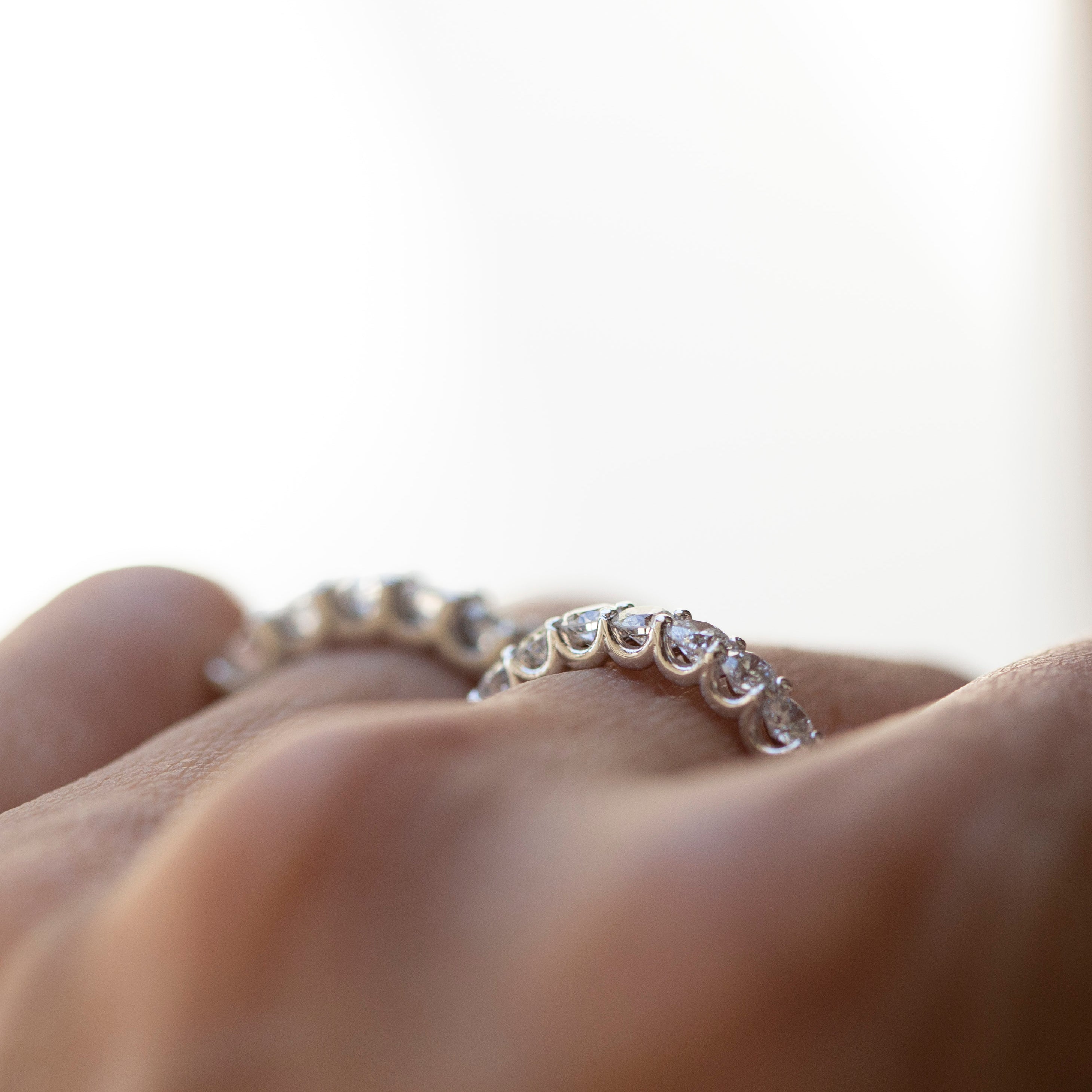 Diamond ring on a finger with a blurred background