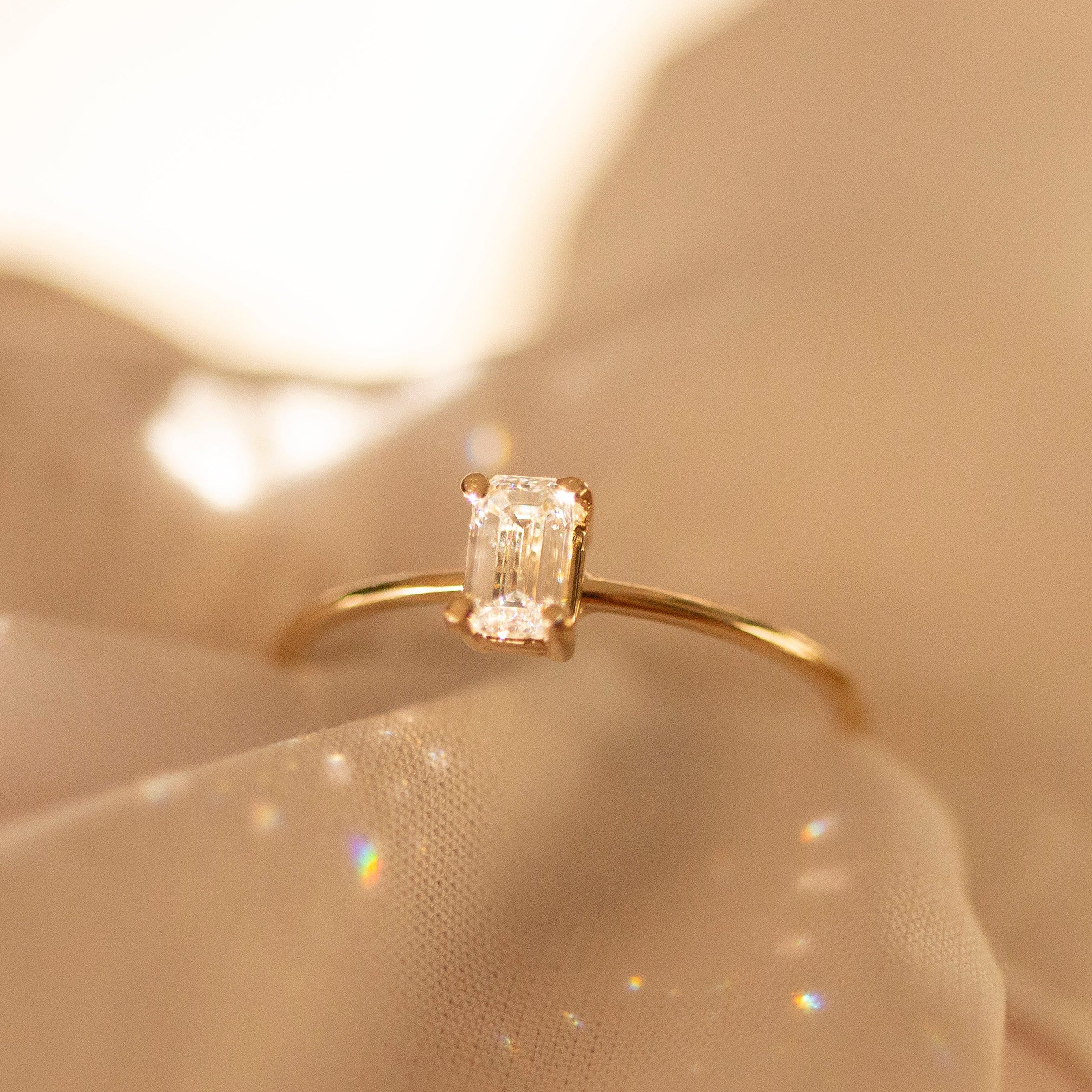 Gold ring with a diamond on a soft beige background