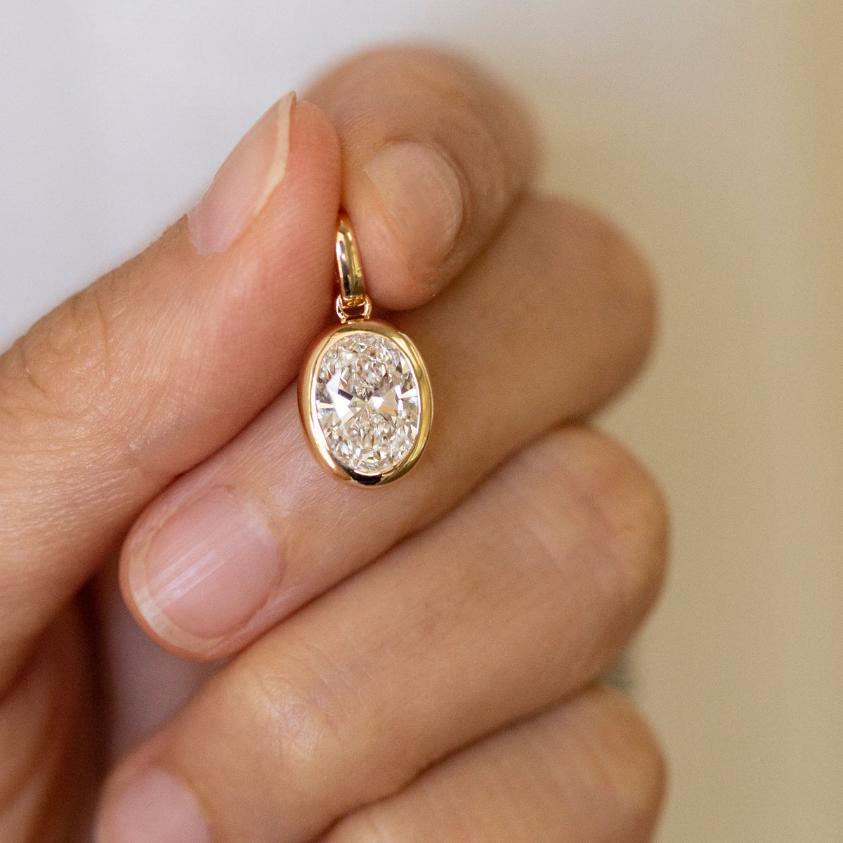 Close-up of oval lab diamond bezel setting, 14k gold