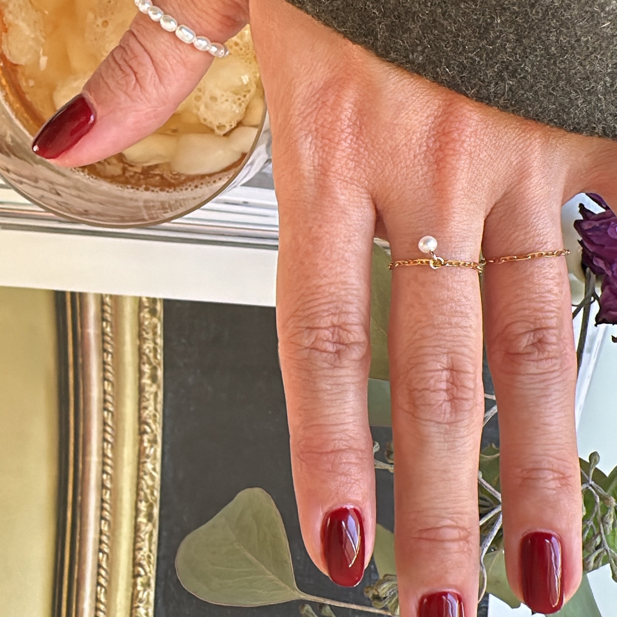 This 14k Solid Gold Chain Ring features a delicate link design and a dainty dangling pearl, creating a modern yet timeless accessory. Worn solo or paired with other rings, it adds a touch of elegance to any look