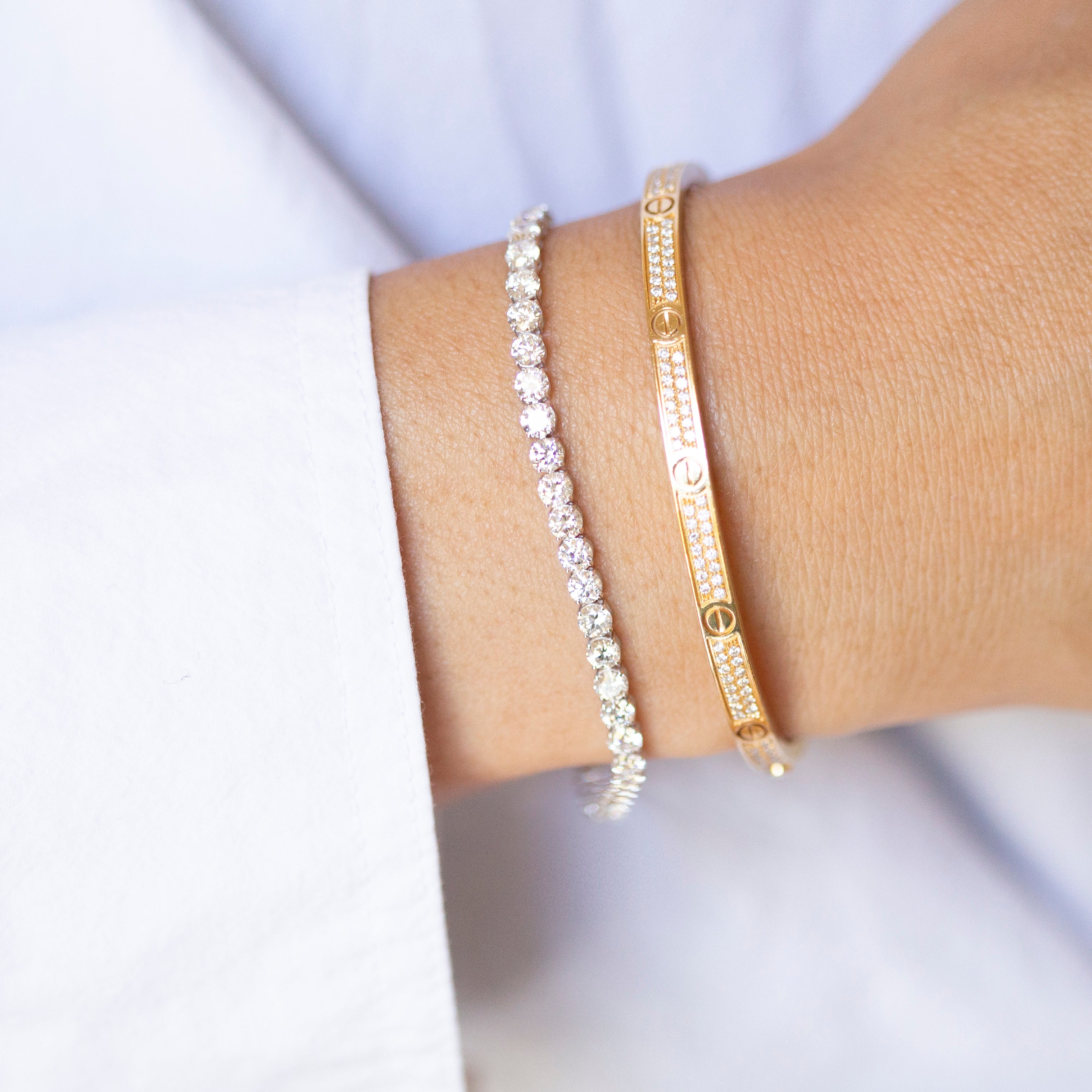 Two bracelets on a wrist against a light background
