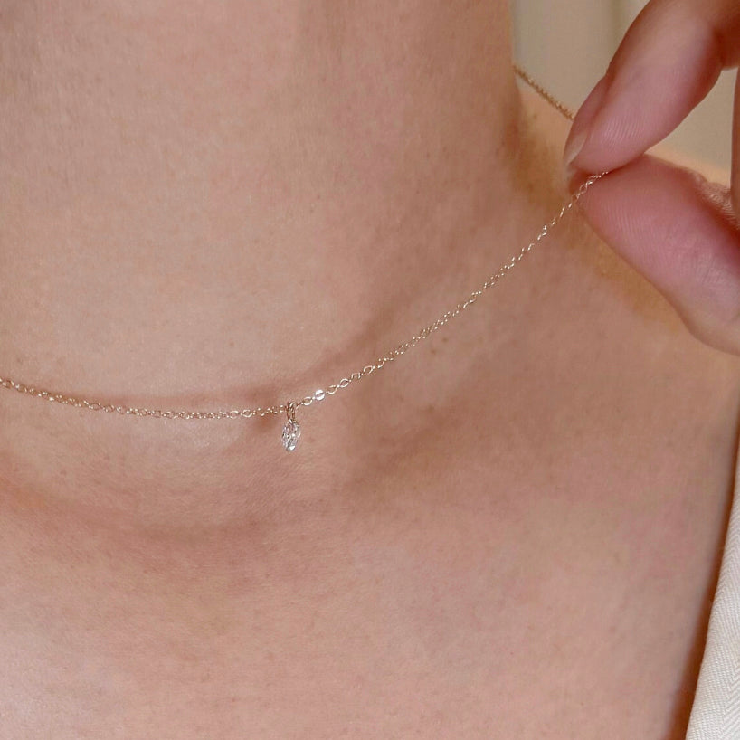 Close-up of a delicate necklace being worn on a person's neck.