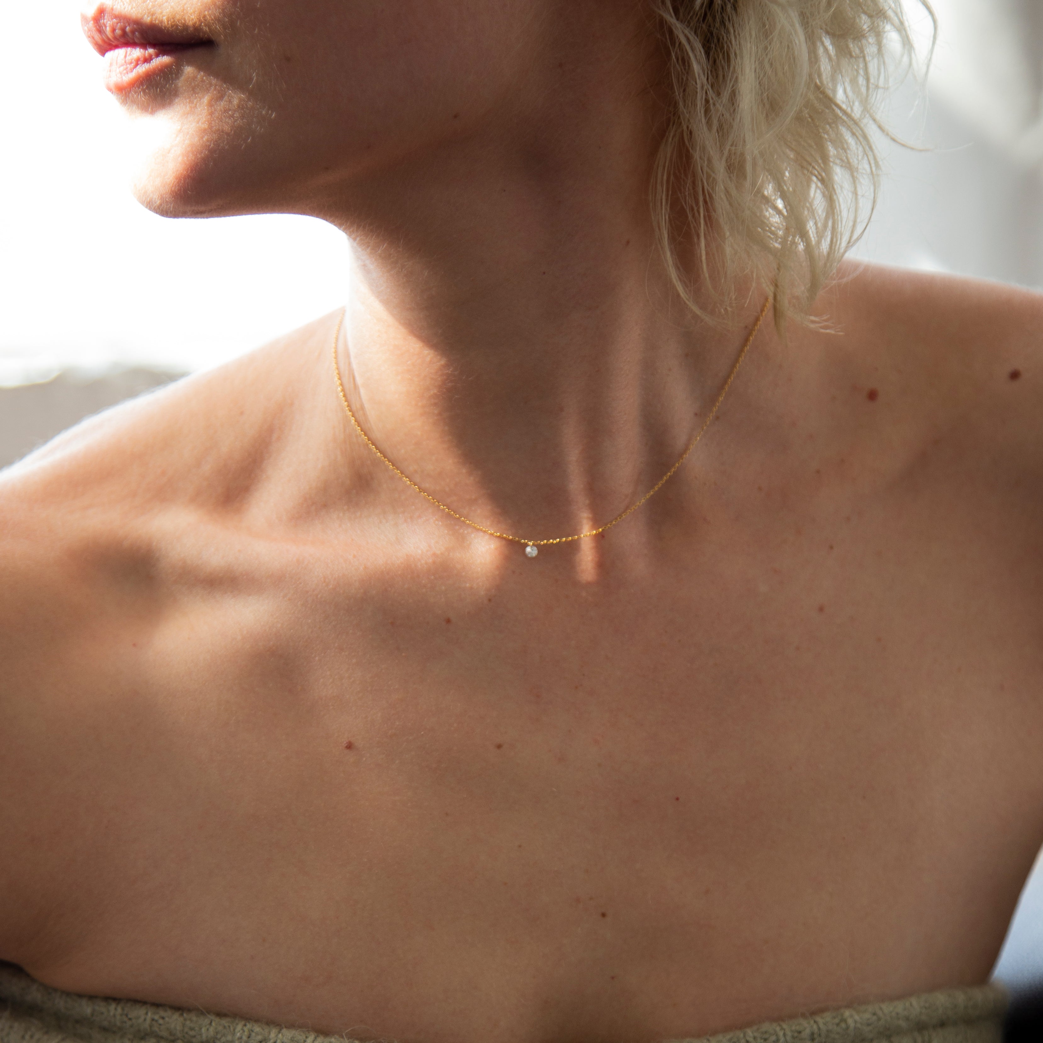 14k Gold chain with beautiful diamond in a drilled jump ring setting
This gorgeous minimalist diamond solitaire necklace features a .1ct round brilliant diamond on a dainty chain as if the diamond was naked.