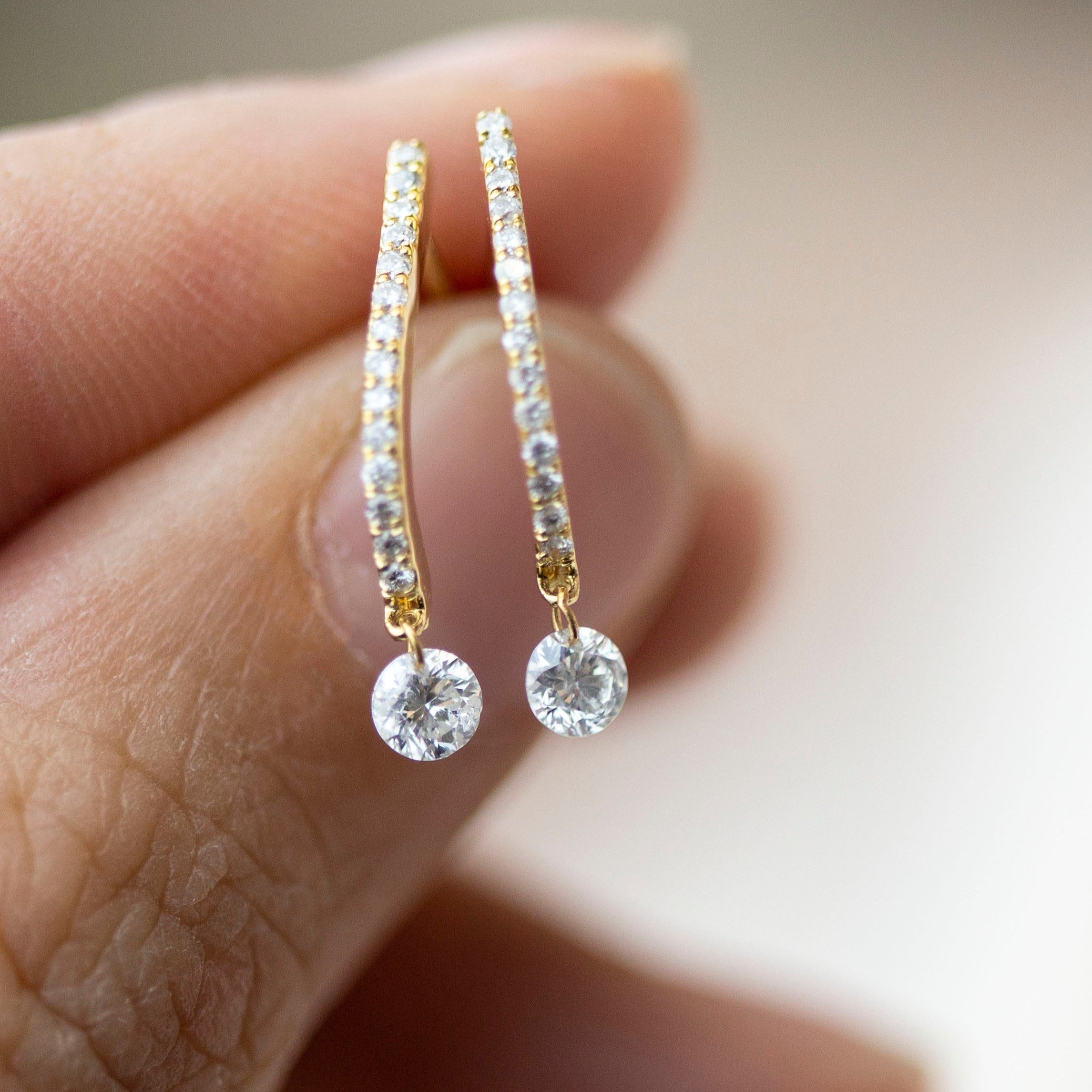 These 14k J-hoop earrings feature a dazzling diamond solitaire drop, adding extra sparkle. They are versatile enough to be worn as an everyday earring or as a statement piece.