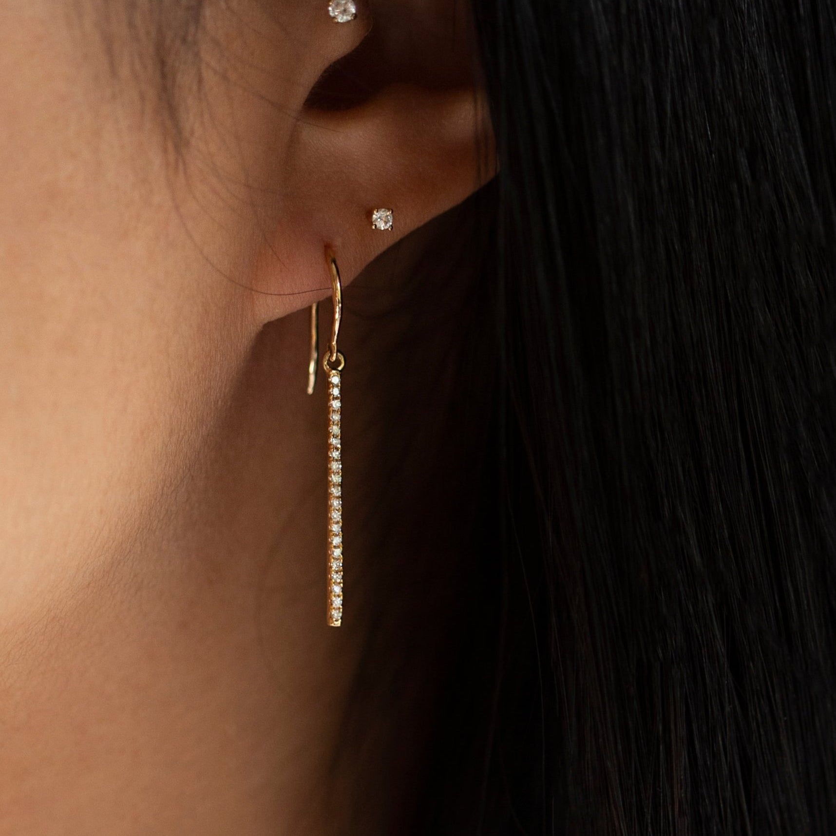 These exquisite 14k gold drop bar earrings feature genuine diamonds, adding a modern touch to their versatile design. A must-have for those seeking a timeless and sophisticated accessory.