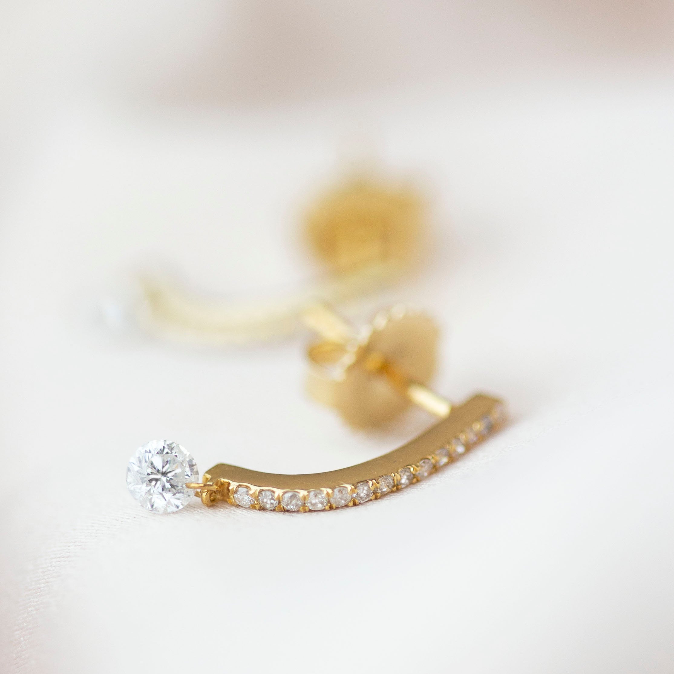 These 14k J-hoop earrings feature a dazzling diamond solitaire drop, adding extra sparkle. They are versatile enough to be worn as an everyday earring or as a statement piece.