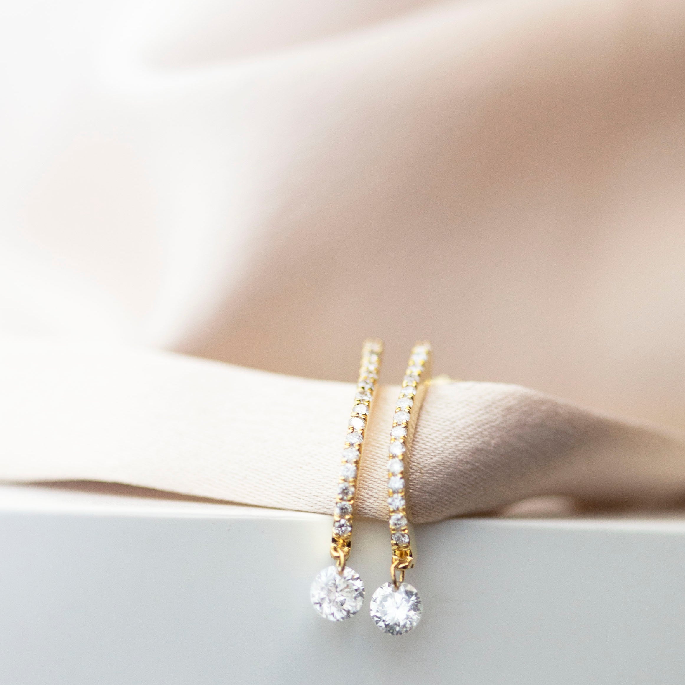 These 14k J-hoop earrings feature a dazzling diamond solitaire drop, adding extra sparkle. They are versatile enough to be worn as an everyday earring or as a statement piece.