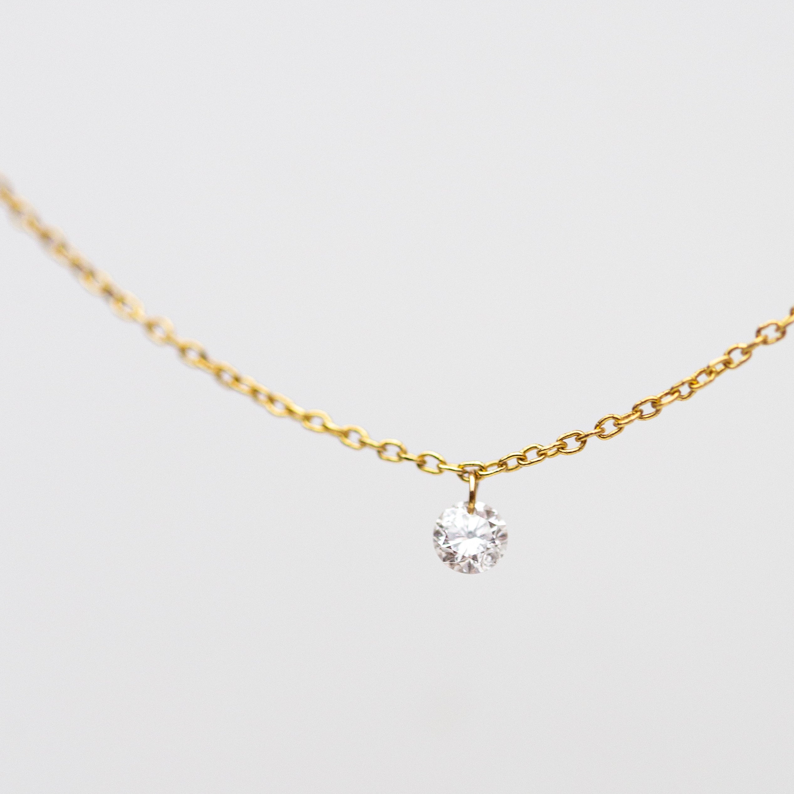 14k Gold chain with beautiful diamond in a drilled jump ring setting
This gorgeous minimalist diamond solitaire necklace features a .1ct round brilliant diamond on a dainty chain as if the diamond was naked.