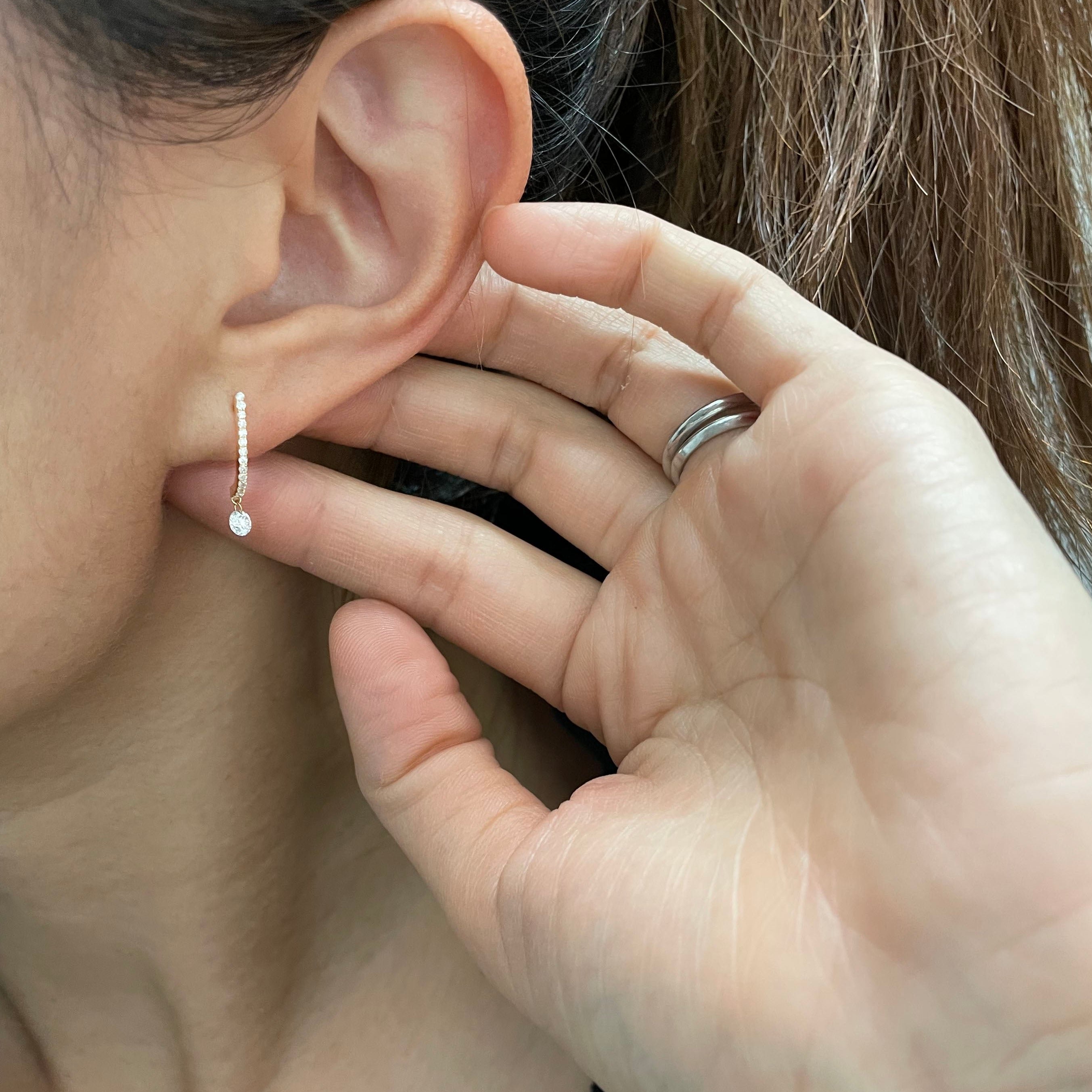 These 14k J-hoop earrings feature a dazzling diamond solitaire drop, adding extra sparkle. They are versatile enough to be worn as an everyday earring or as a statement piece.