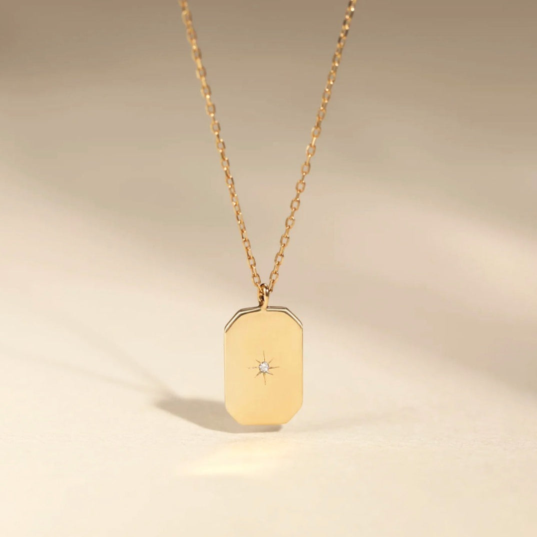 This 14k Gold Mini Diamond Tag Necklace is minimalistic and simple, yet adds a special touch with its small diamond star tag. It provides the perfect everyday accessory when worn alone or layered with other necklaces.