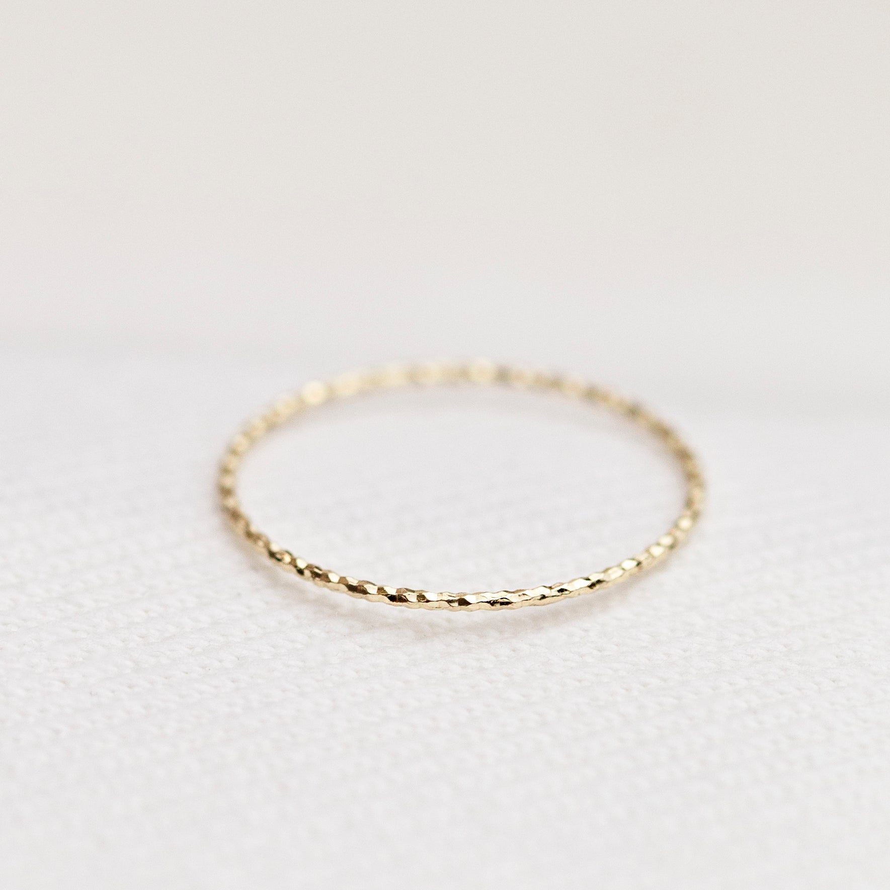 Crafted from 14k gold and featuring a diamond-cut design, these stacking rings offer a dainty and simplistic look that is perfect for everyday wear.