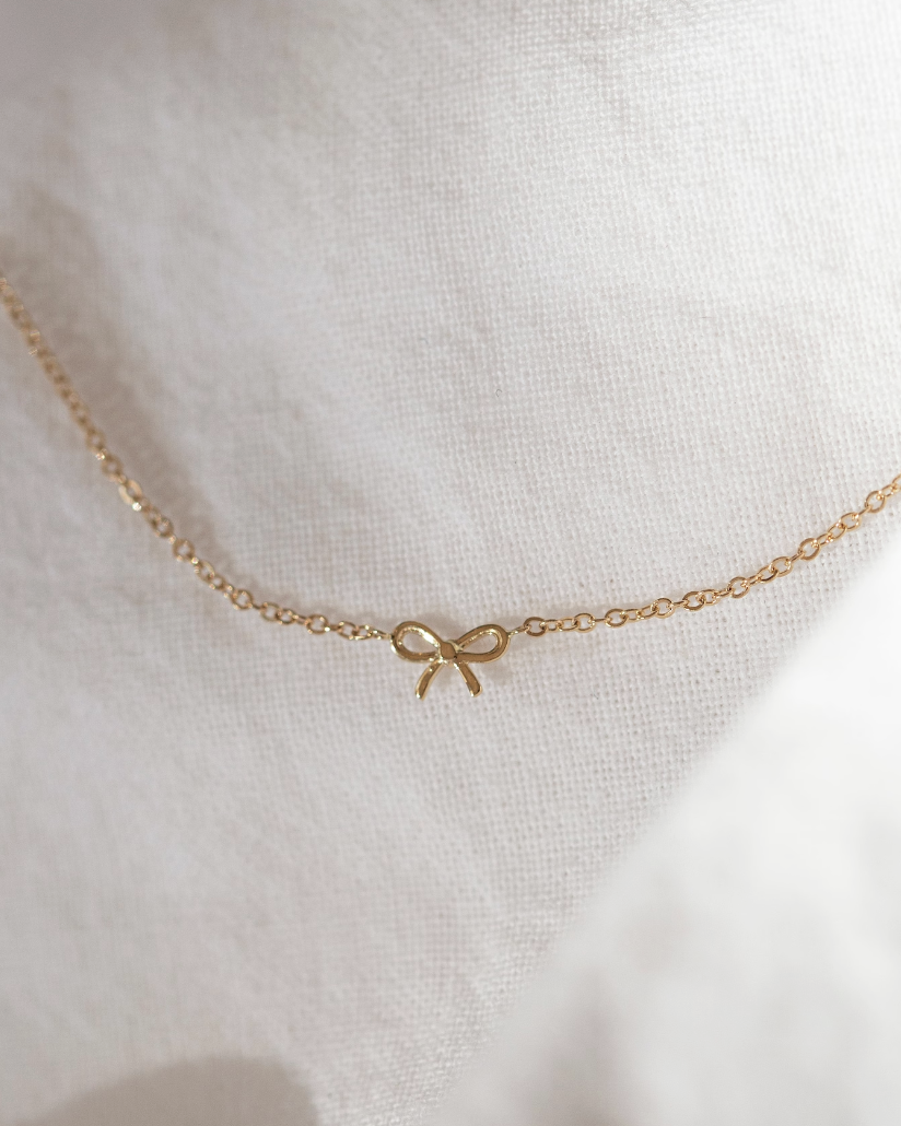 This 14k gold bracelet features a delicate bow, making it ideal for everyday wear. Its petite design is perfect for making a subtle statement.