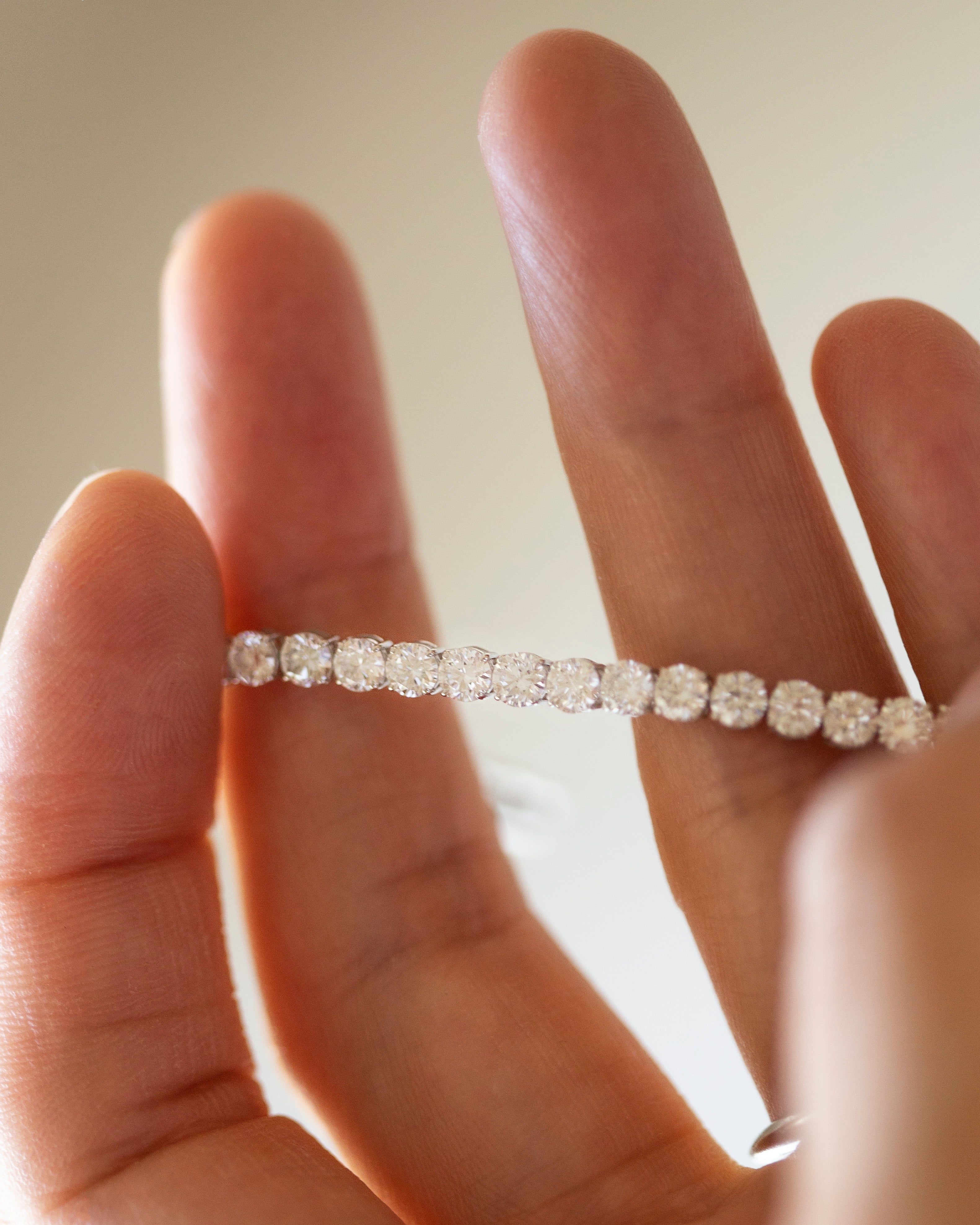 Diamond bracelet on a person's wrist with a neutral background