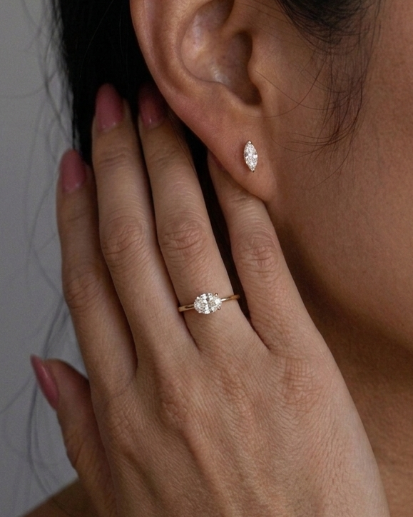 Close-up of a hand with a ring and an earring, focusing on jewelry details.