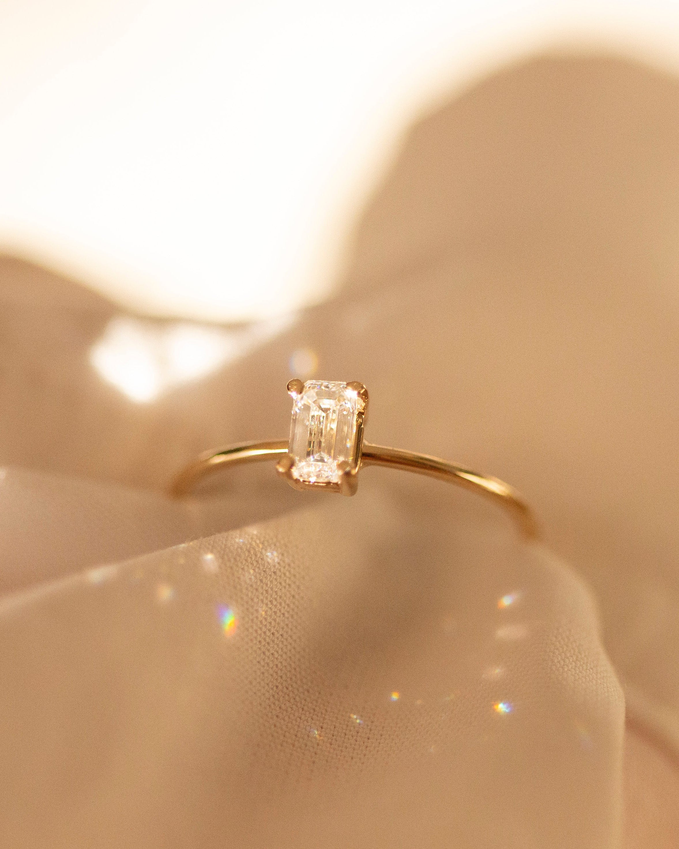 Gold ring with a diamond on a soft beige background