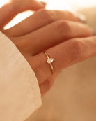 Gold ring with a diamond on a hand against a blurred background