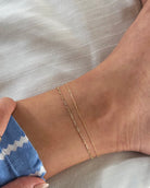 Our dainty chain anklet is the perfect accessory to elevate your summer style. Its subtle sparkle exudes elegance and sophistication, while also catching the eye with its glimmering light. Made from premium materials, this lightweight and durable anklet is designed to drape around the ankle beautifully, giving you a timeless look to wear day or night.