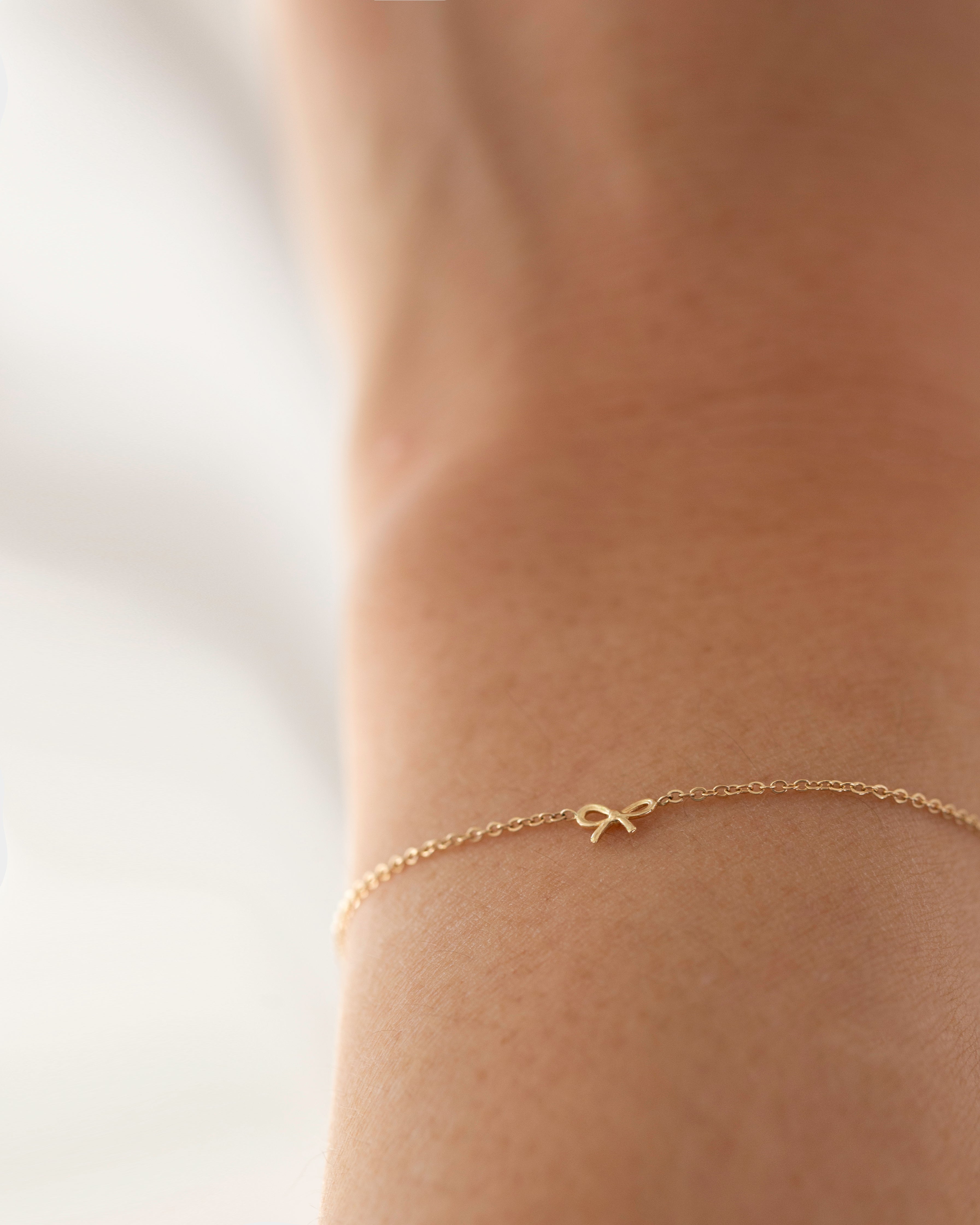 This 14k gold bracelet features a delicate bow, making it ideal for everyday wear. Its petite design is perfect for making a subtle statement.