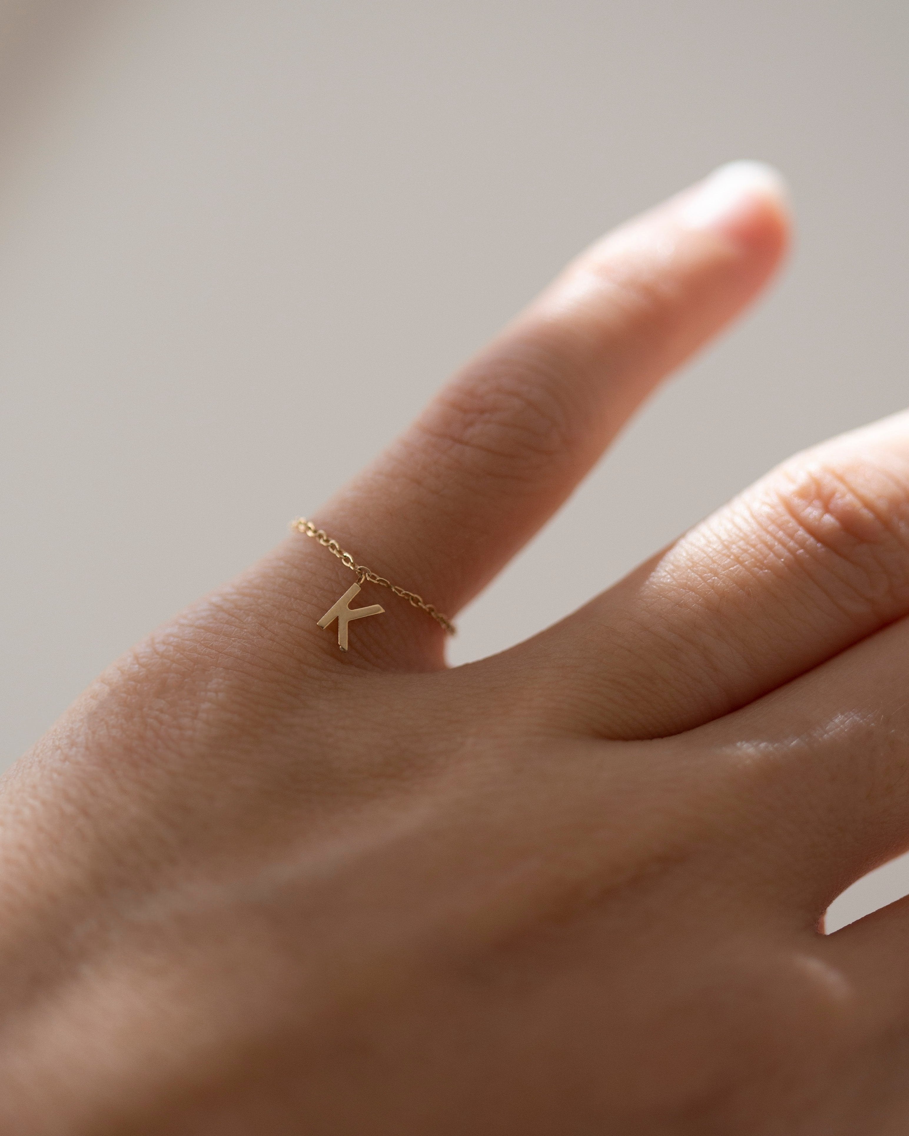 Barely there ring in 14k gold with a small initial letter dangle