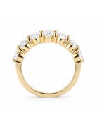 A yellow gold ring featuring a curved row of clear oval-cut gemstones in a prong setting, shown against a plain white background.