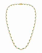 A yellow gold tennis necklace featuring small round-cut green emeralds and rows of clear pavé-set round stones, arranged in a scalloped pattern on a plain white background.