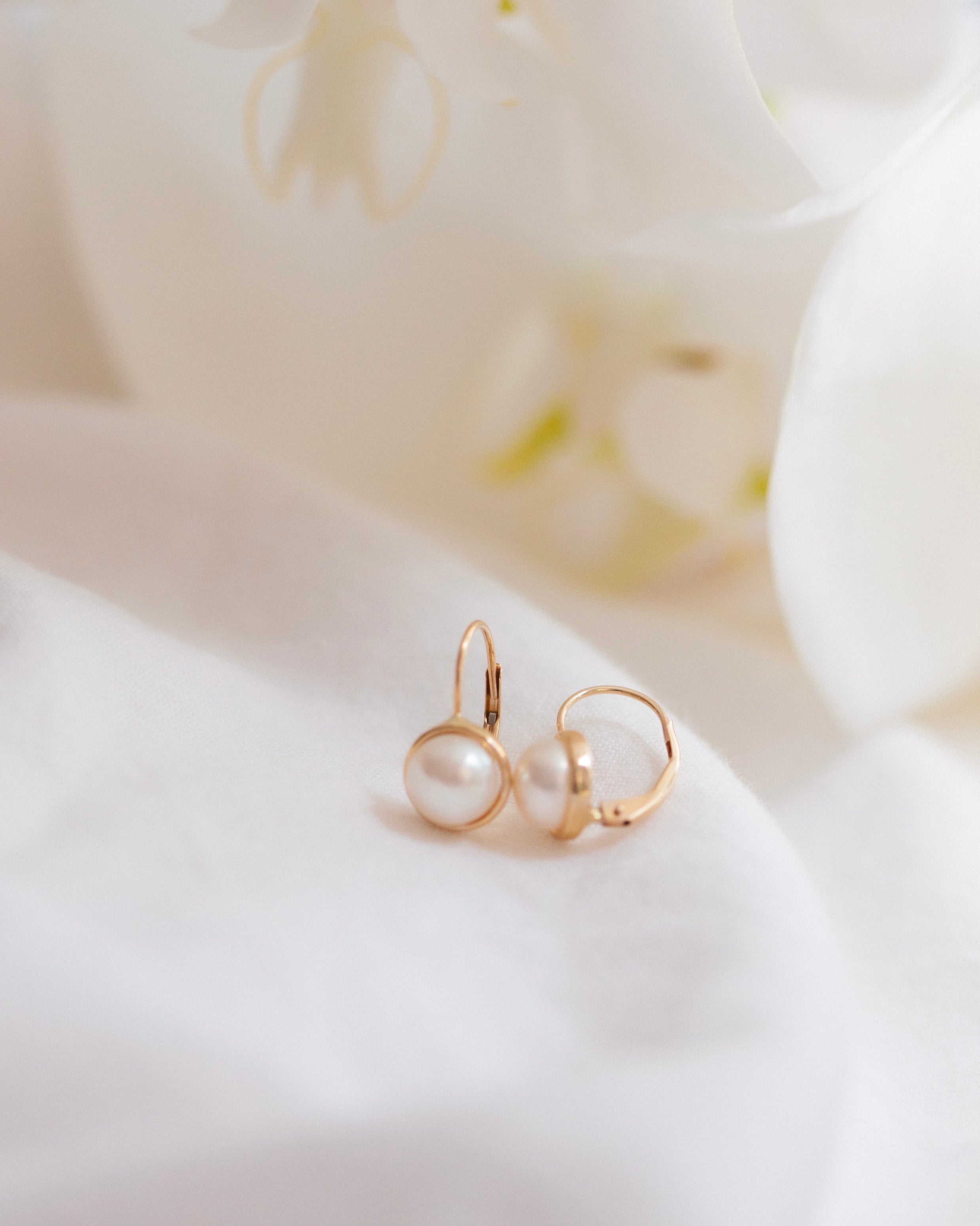 These 14k gold earrings feature a 7mm white cultured pearl and secure lever back closure.