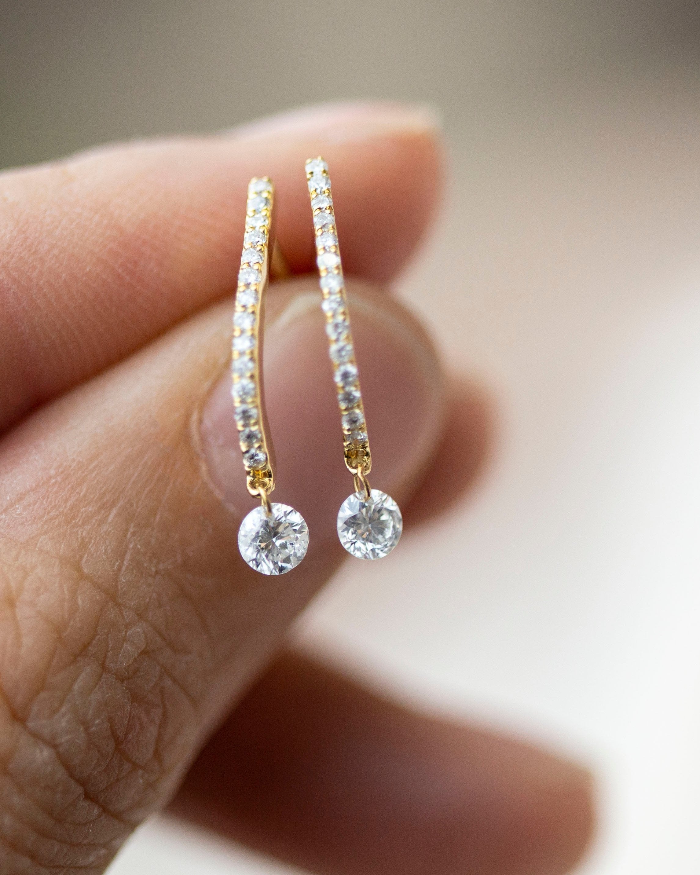 These 14k J-hoop earrings feature a dazzling diamond solitaire drop, adding extra sparkle. They are versatile enough to be worn as an everyday earring or as a statement piece.