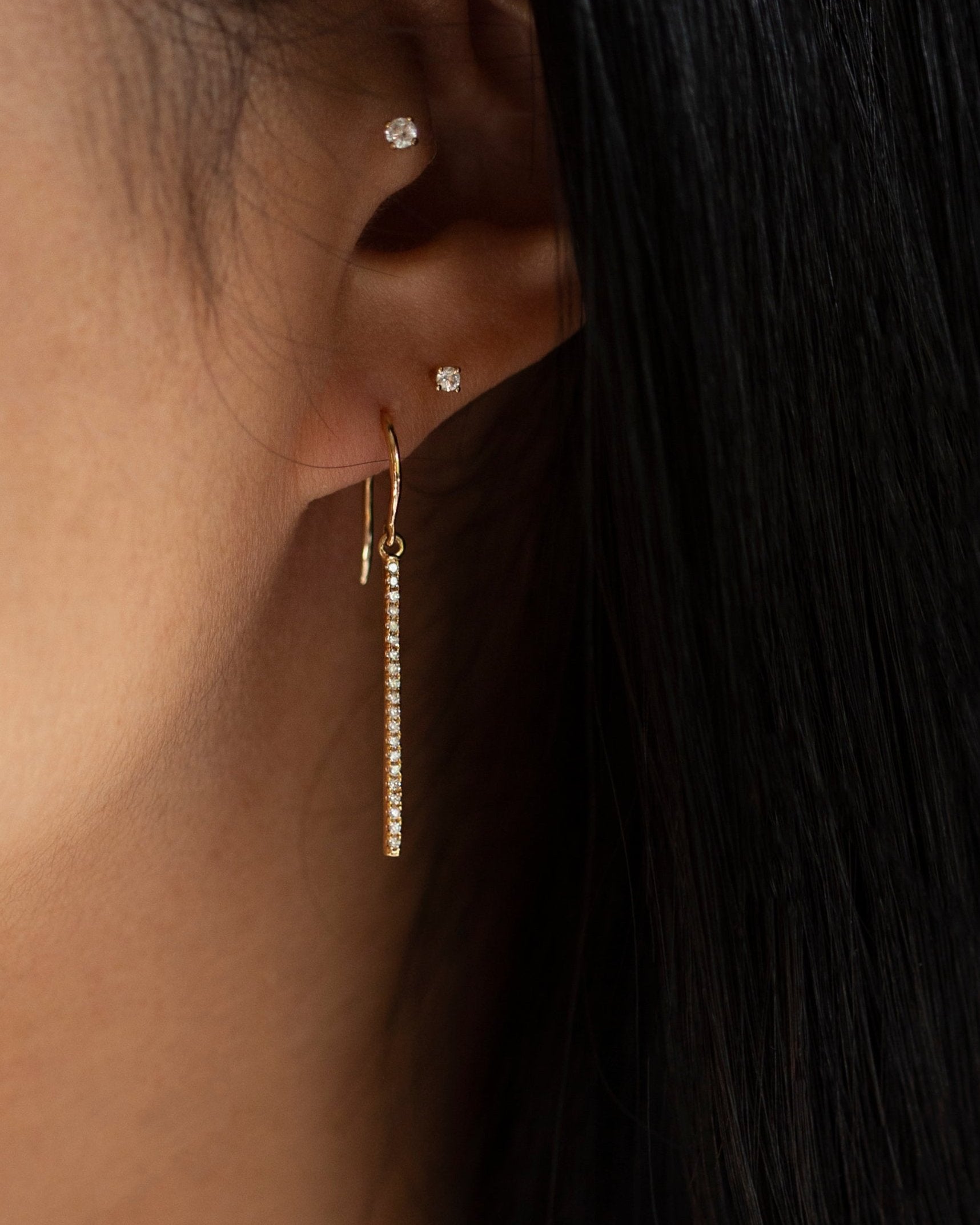 These exquisite 14k gold drop bar earrings feature genuine diamonds, adding a modern touch to their versatile design. A must-have for those seeking a timeless and sophisticated accessory.