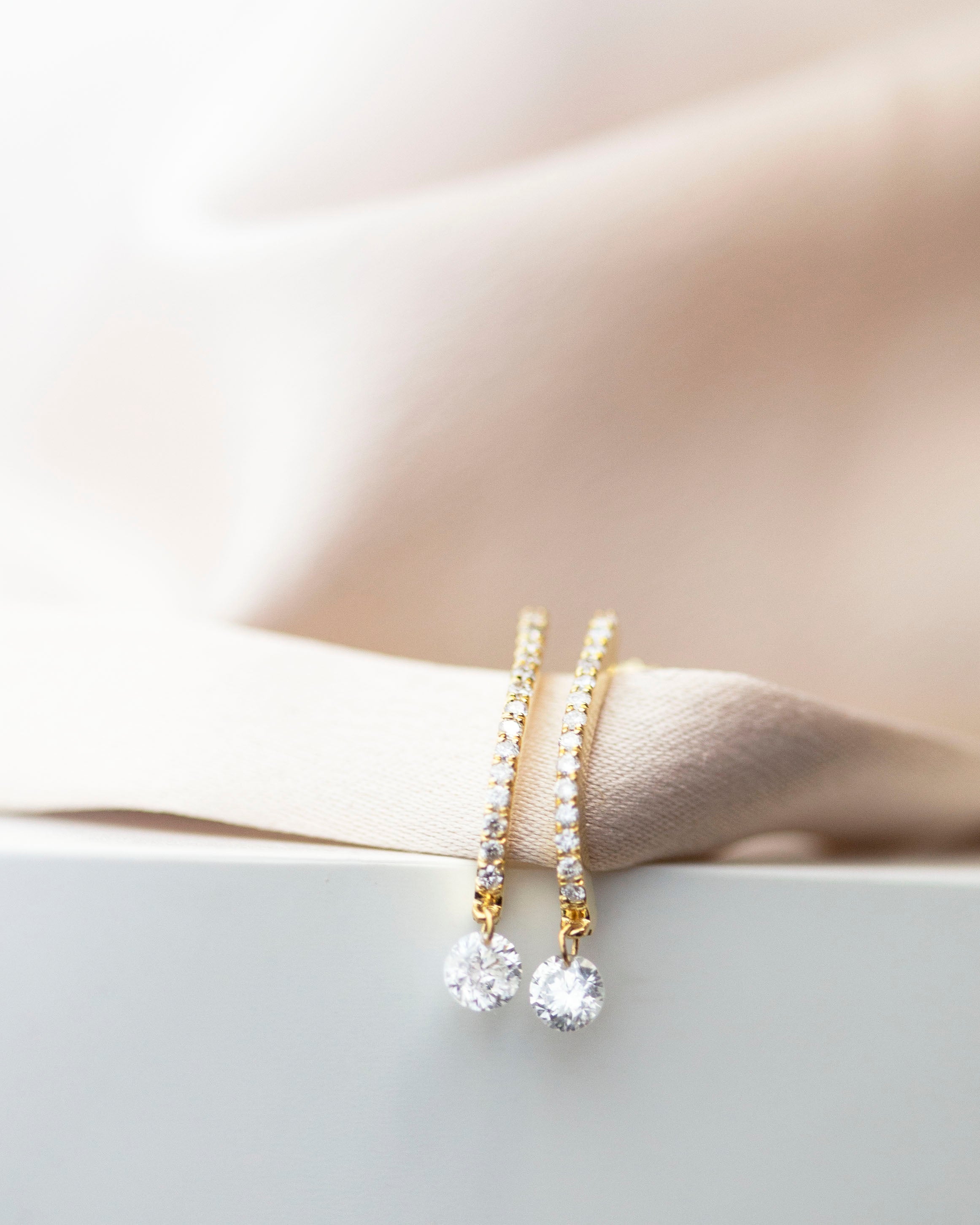These 14k J-hoop earrings feature a dazzling diamond solitaire drop, adding extra sparkle. They are versatile enough to be worn as an everyday earring or as a statement piece.
