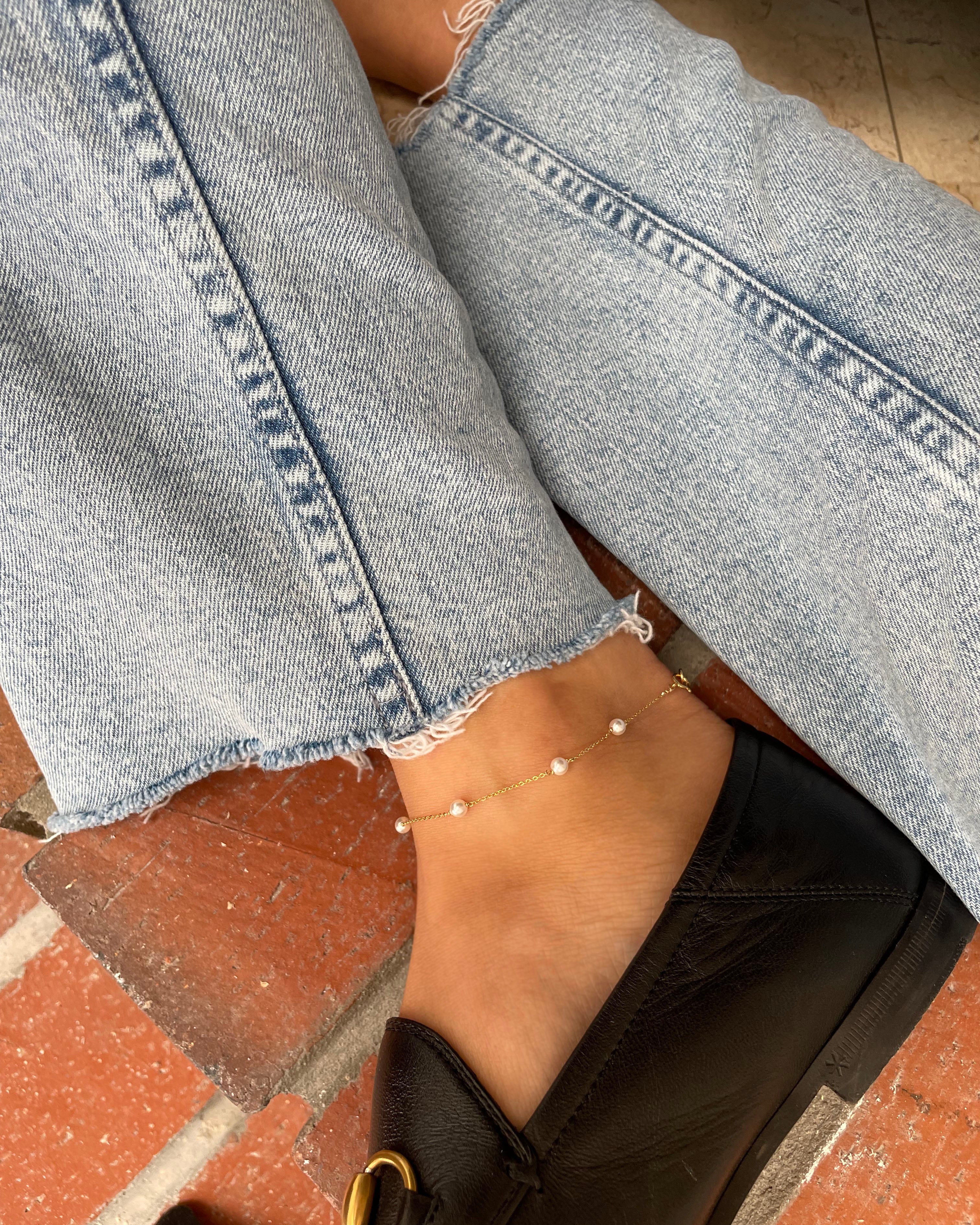 A gold chain anklet with small white pearls